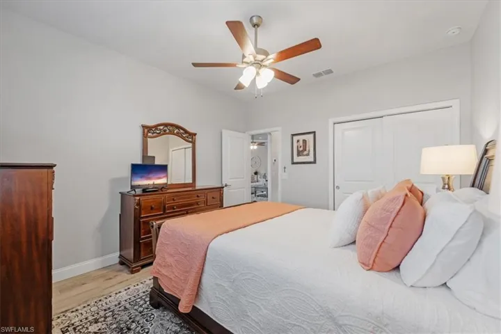 Bedroom with a closet, ceiling fan, and light hardwood / wood-style flooring