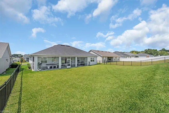 Rear view of property with a lawn