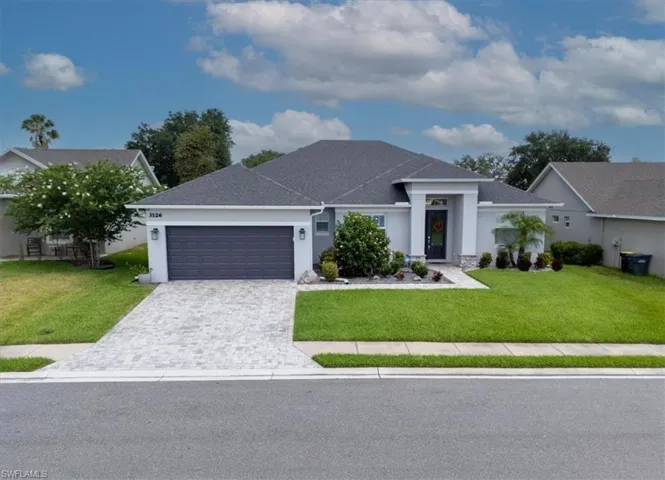 View of front of house featuring a garage and a front lawn