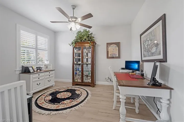 Home office with ceiling fan and light hardwood / wood-style flooring