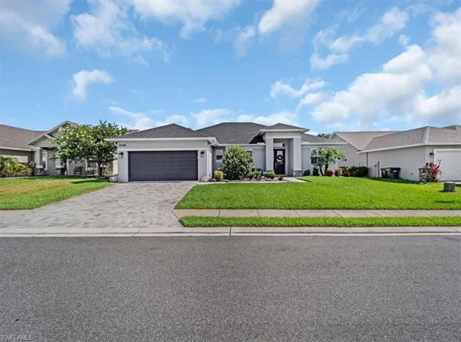 View of front of home featuring a garage and a front lawn