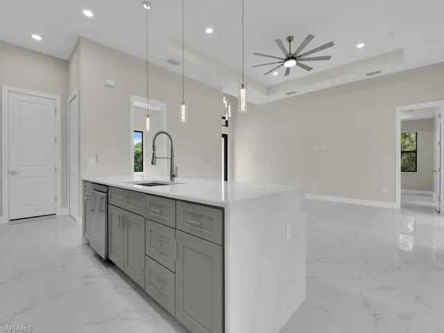 Kitchen with gray cabinetry, light marble finish flooring, stainless steel dishwasher, open floor plan, and recessed lighting