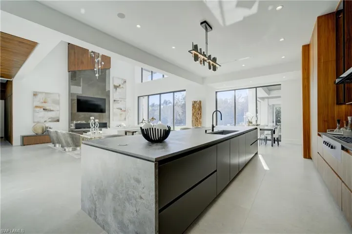 Kitchen with decorative light fixtures, a large island, and sink