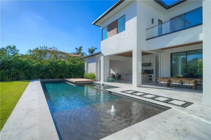View of pool with pool water feature and a patio area
