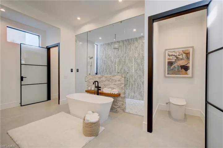 Bathroom with shower with separate bathtub, toilet, tile walls, and tile patterned floors
