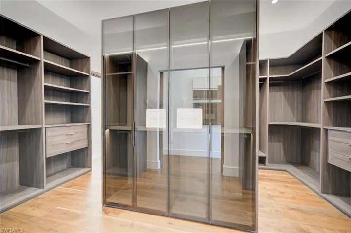 Spacious closet with light hardwood / wood-style flooring