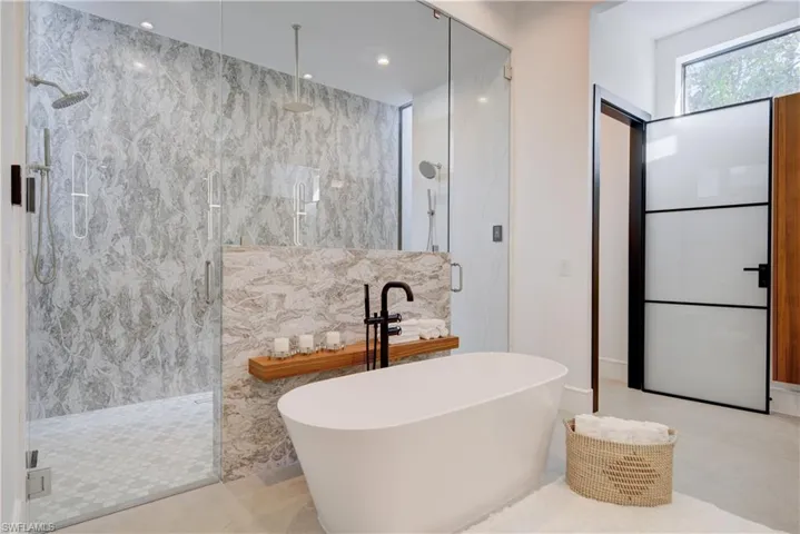 Bathroom featuring tile patterned floors, shower with separate bathtub, and tile walls