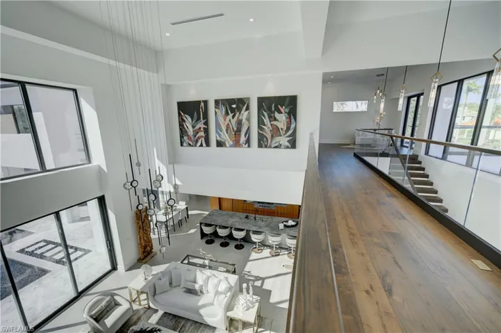 Living room with hardwood / wood-style floors and a towering ceiling