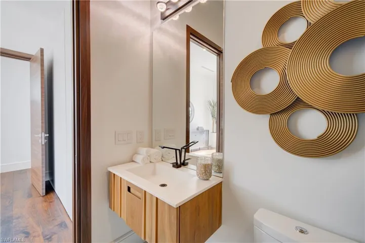 Bathroom with vanity, hardwood / wood-style flooring, and toilet