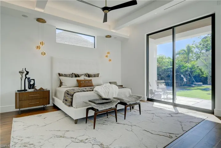 Bedroom featuring beamed ceiling, ceiling fan, wood-type flooring, and access to outside