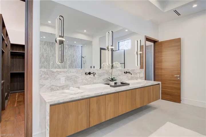 Bathroom with decorative backsplash, wood-type flooring, and vanity