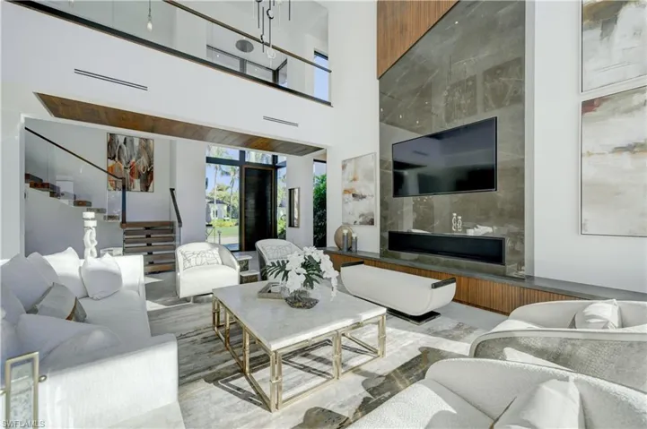 Living room featuring light wood-type flooring and a high ceiling