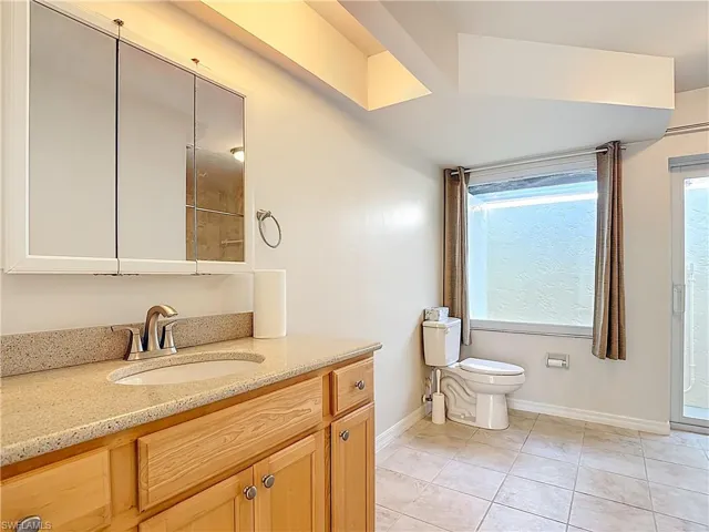 Full bath with light tile patterned floors vanity, and a shower