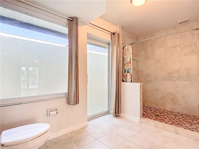 Bathroom with a stall shower and tile patterned floors