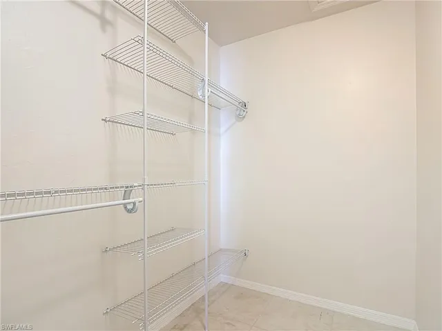 Spacious closet with light tile patterned floors
