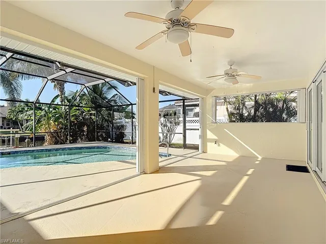 Swimming pool with a sunroom, a patio area, a lanai, and ceiling fan