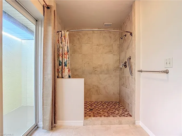 Full bath featuring a stall shower and tile patterned floors
