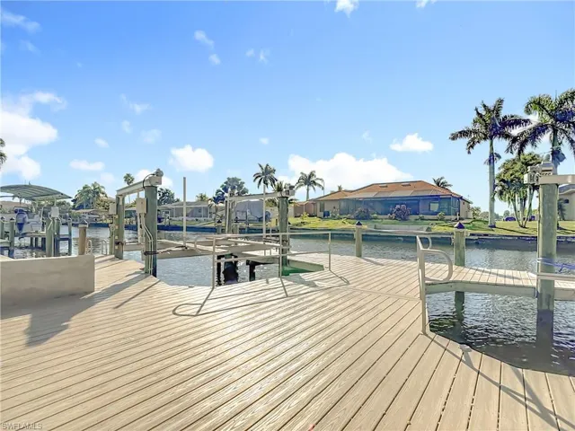 Dock featuring boat lift, a water view, and a residential view