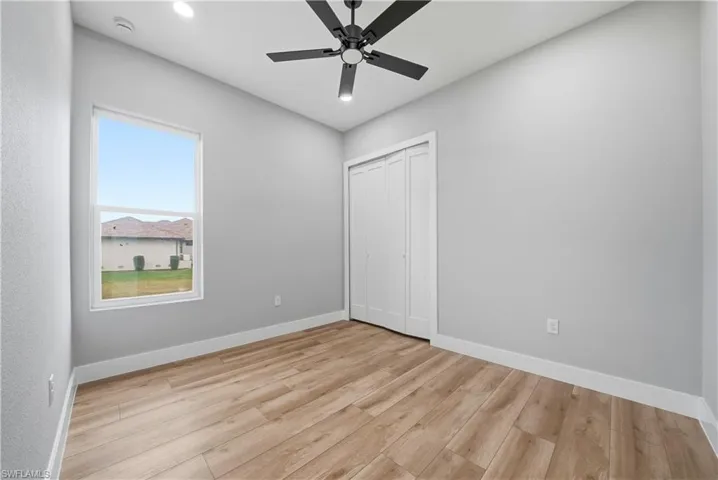 Unfurnished bedroom with light wood-style floors, ceiling fan, recessed lighting, and a closet