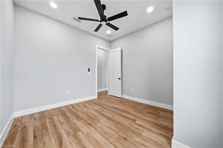 Empty room featuring light wood-style flooring, a ceiling fan, and recessed lighting