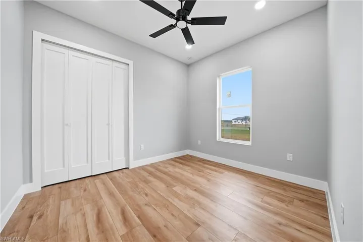 Unfurnished bedroom featuring a ceiling fan, recessed lighting, light wood-type flooring, and a closet