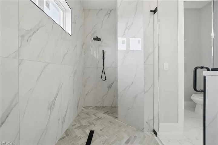 Bathroom featuring a marble finish shower