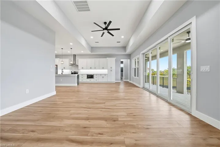 Unfurnished living room featuring a ceiling fan, light wood finished floors, and recessed lighting