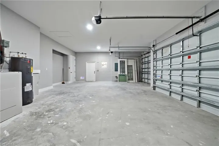 Garage featuring water heater and a garage door opener