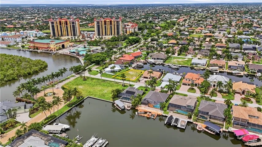 Waterfront lot with direct Gulf access, featuring a seawall, mature palm trees, and canal frontage