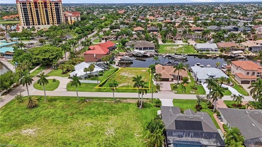 Canal-front lot featuring mature palm trees and direct water access