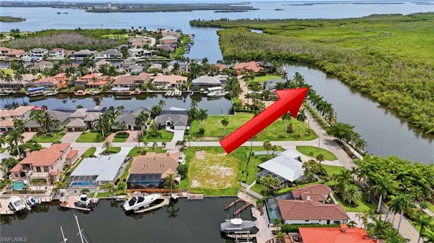 Waterfront property with canal access, featuring surrounding residential properties and mature landscaping