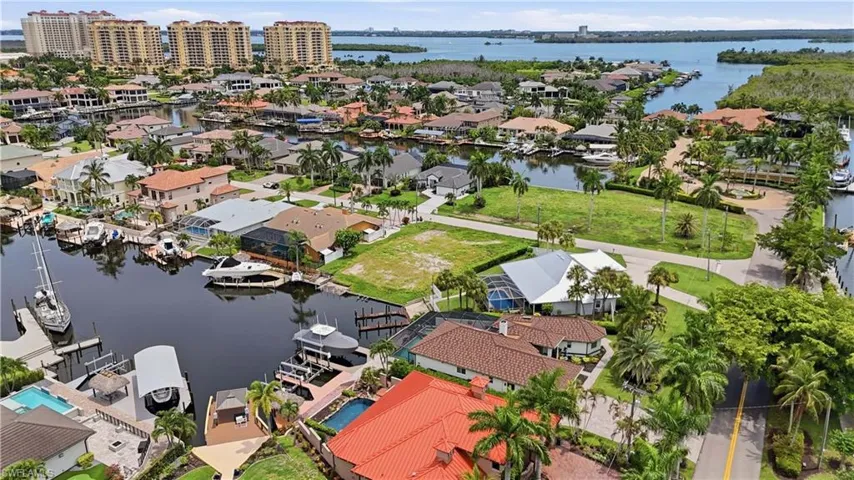Aerial perspective showcasing a canal-front community with multiple properties featuring private docks and boat lifts