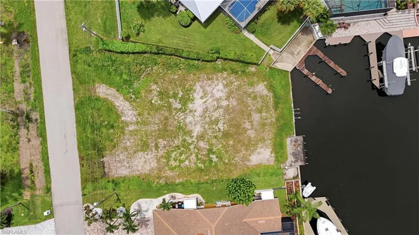 Waterfront lot featuring direct canal access, a paved road frontage, and an existing concrete seawall