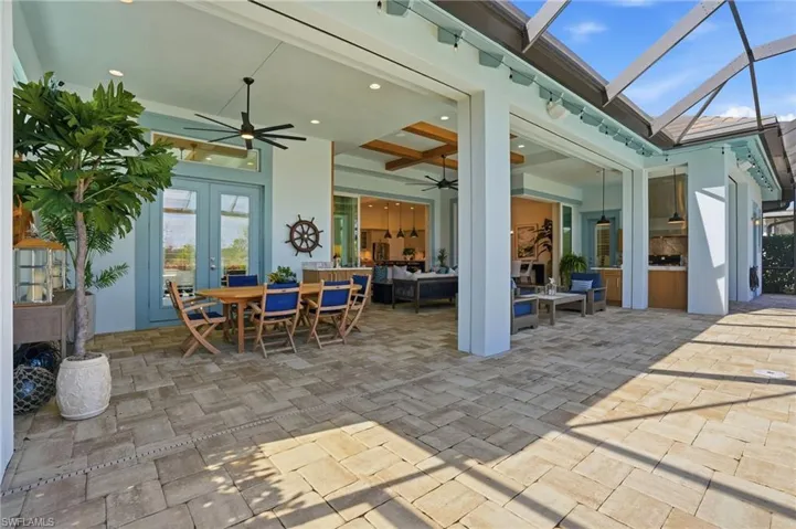 Covered lanai featuring paver flooring, recessed lighting, ceiling fans, and an integrated outdoor kitchen