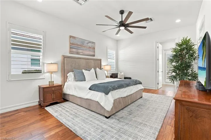Room featuring wood-finish flooring, recessed lighting, multi-blade ceiling fan, and plantation shutters