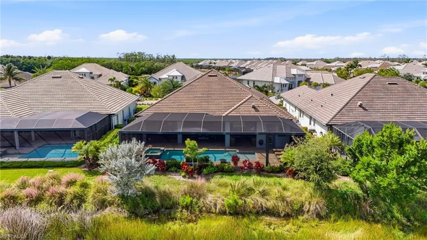 Screened-in rear patio featuring an inground swimming pool, integrated spa, and tiled decking