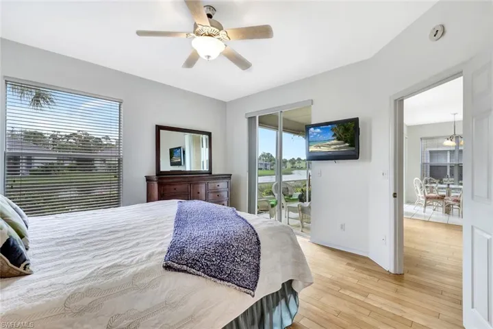 Bedroom featuring access to exterior, multiple windows, light wood finished floors, and a ceiling fan