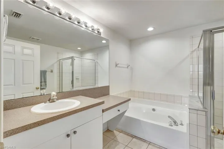 Full bathroom featuring a garden tub, tile patterned flooring, vanity, visible vents, and a shower stall
