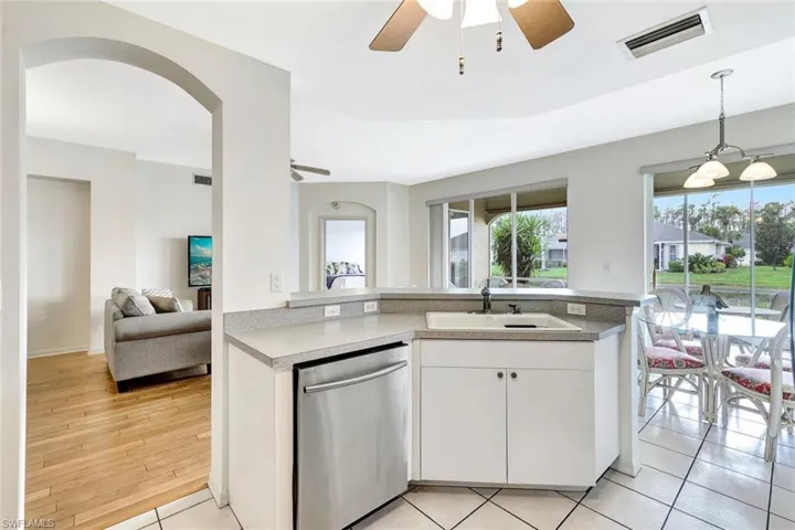 Kitchen featuring visible vents, stainless steel dishwasher, open floor plan, white cabinetry, and a sink