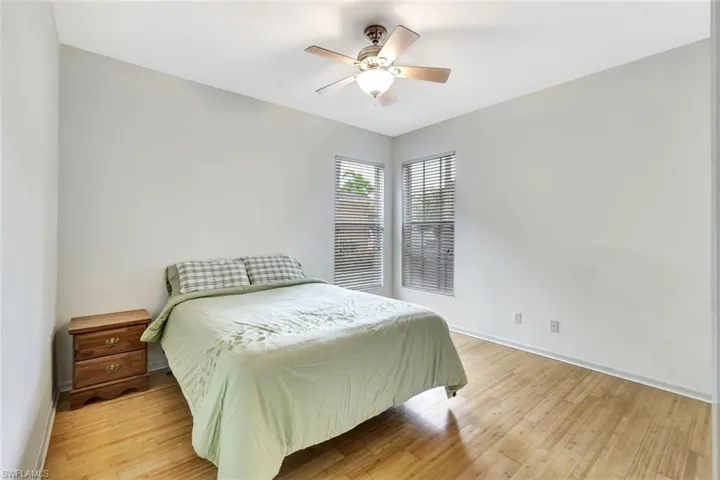Bedroom with light wood-style floors, ceiling fan, and baseboards