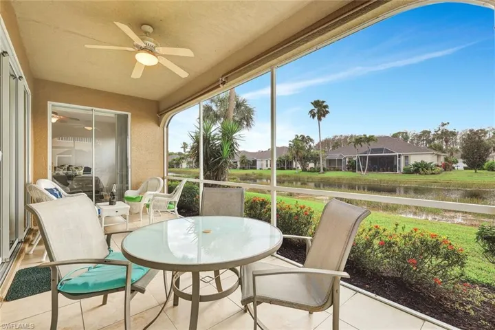Sunroom with a water view and a ceiling fan