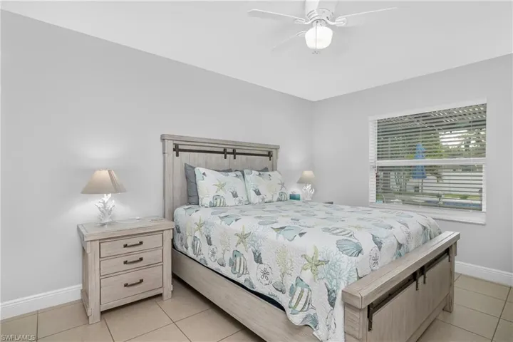 Tiled bedroom featuring ceiling fan