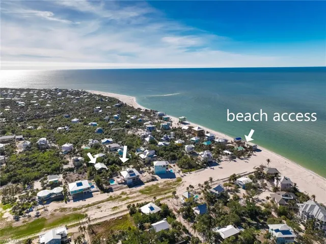 Birds eye view of property with a water view and a view of the beach