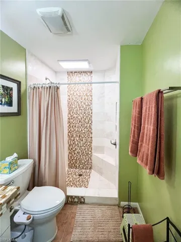Bathroom with curtained shower and toilet