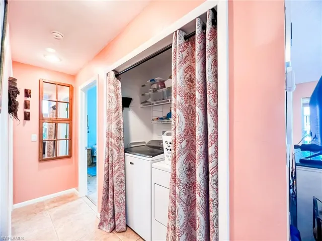 Laundry area featuring separate washer and dryer and light tile patterned flooring