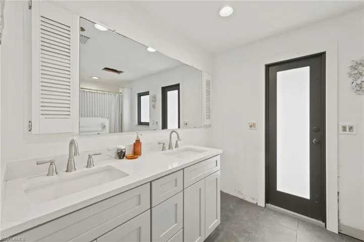 Full bathroom featuring double vanity, recessed lighting, and tile patterned flooring