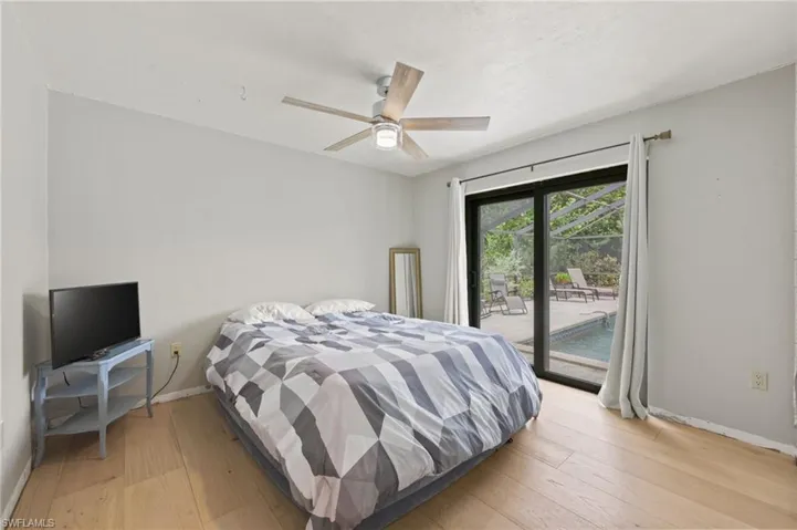 Bedroom featuring access to exterior, light wood-type flooring, and a ceiling fan