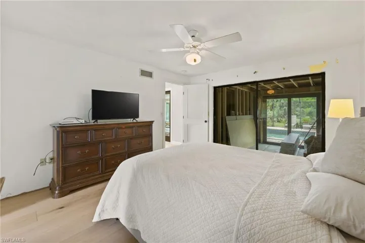 Bedroom with light wood-type flooring, access to exterior, and a ceiling fan