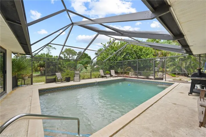 Outdoor pool featuring a patio area and glass enclosure