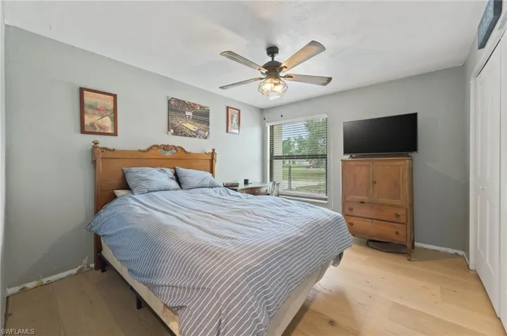 Bedroom with a closet, light wood-style floors, and ceiling fan